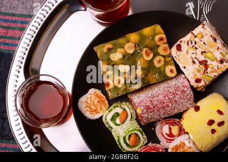 Blick von oben auf verschiedene traditionelle türkische Köstlichkeiten mit Nüssen und Teegläsern Stockfoto