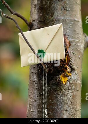 Geschlossener brauner Papierumschlag mit grünem Siegel auf einen Baum gelegt Stockfoto