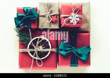 Geschenke verpackt in buntem Papier mit Schleifen. Weihnachtskonzept. Draufsicht, flach liegend. Stockfoto