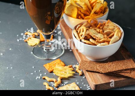 Ein Glas dunkles Bier mit einer Schüssel Bier Snacks in der Nähe Nach oben Stockfoto