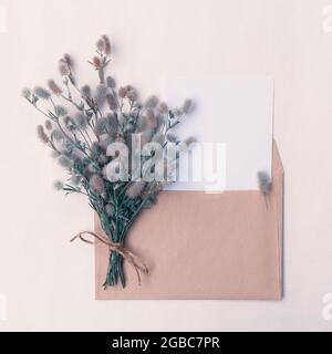 Karte mit einem Strauß wilder, flauschiger Blumen in einem Umschlag mit Platz für das Design Stockfoto