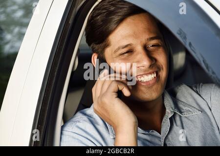 Indischer Mann, der während der Fahrt telefoniert Stockfoto