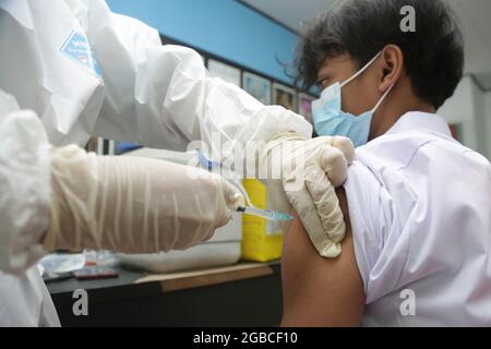 Ein Gesundheitsmitarbeiter injiziert einem Studenten des Impfzentrums Covid-19 in Balai Pustaka, Ost-Jakarta, den Sinovac-Biotech-Impfstoff Covid-19. Diese Impfaktivitäten zielen darauf ab, das Massenimpfungsprogramm der Regierung der Republik Indonesien zu beschleunigen und erfolgreich durchzuführen, um den Umgang mit der Covid-19-Pandemie zu beschleunigen, so dass eine Herdenimmunität gebildet werden kann. (Foto von Kuncoro Widyo Rumpoko/Pacific Press) Stockfoto