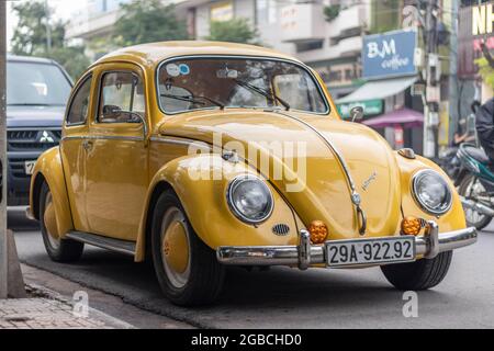 Nha Trang, Provinz Khanh Hoa, Vietnam - 9. Januar 2019: Ein alter gelber Volkswagen-Käfer steht auf einem Parkplatz in der Nähe des Bürgerwegs. Ausgezeichneter Stand Stockfoto