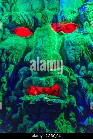 Groteske grüne Monster Kopf mit roten Augen und Mund. Gefunden in der Grotte unter dem Labyrinth in Leeds Castle kent england Stockfoto