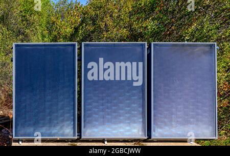 3 Solar-Wasser-Heizpaneele umweltfreundliche und erneuerbare Energielösung in einem Garten Algarve Portugal Stockfoto