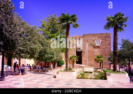 Menschen essen und trinken auf einem Platz vor dem Eingang zum Schloss Silves. Silves Algarve Portugal. Stockfoto