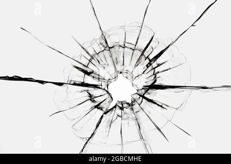 Risse im Fenster von einem Schuss aus einer Waffe. Beschädigtes Fensterglas. Stockfoto