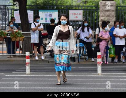 Peking, China. August 2021. Eine Frau, die eine Gesichtsmask trägt, als Vorsichtsmaßnahme gegen die Ausbreitung von covid-19, geht entlang der Dongdan North Street in Peking, in der Nähe des Pekinger Union Medical College Krankenhauses und des Pekinger Lijun Hotels. (Foto von Sheldon Cooper/SOPA Images/Sipa USA) Quelle: SIPA USA/Alamy Live News Stockfoto