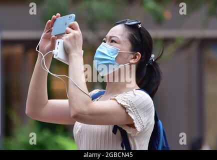 Peking, China. August 2021. Als Vorsichtsmaßnahme gegen die Verbreitung von covid-19 sah eine Touristin, die eine Gesichtsmask trug, Selfies in der Handelsstraße Wangfujing in Peking machen. (Foto von Sheldon Cooper/SOPA Images/Sipa USA) Quelle: SIPA USA/Alamy Live News Stockfoto