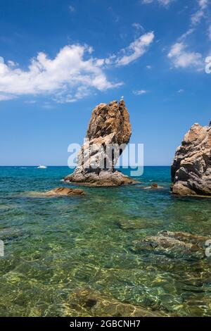 Cefalù, Palermo, Sizilien, Italien. Aus dem klaren, flachen Wasser der Calura Bay, einer geschützten Bucht des Tyrrhenischen Meeres, ragt ein hoch aufragender Felsblock hervor. Stockfoto