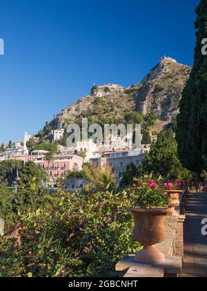 Taormina, Messina, Sizilien, Italien. Blick von den Gärten der Villa Comunale auf die Kapelle der Madonna della Rocca und die Ruinen der Burg Sarazenen. Stockfoto