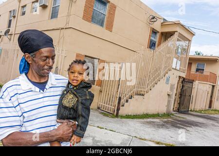 Miami Florida, Overtown, Stadt mit niedrigem Einkommen, schwarzer Mann, Junge, Baby, Großvater, Sohn, Elternteil, das Kind hält, Stockfoto