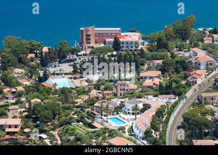 Cefalù, Palermo, Sizilien, Italien. Blick auf die Hotelgärten vom Gipfel von La Rocca, dem noch türkisfarbenen Wasser der Calura Bay dahinter. Stockfoto