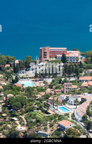 Cefalù, Palermo, Sizilien, Italien. Blick auf die Hotelgärten vom Gipfel von La Rocca, dem noch türkisfarbenen Wasser der Calura Bay dahinter. Stockfoto