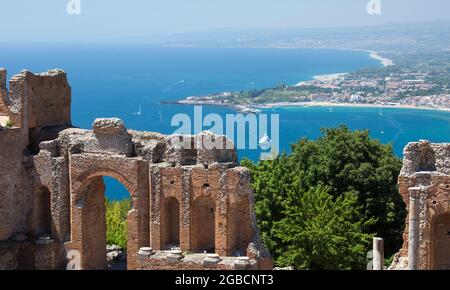 Taormina, Messina, Sizilien, Italien. Blick vom Griechischen Theater über das türkisfarbene Wasser der Bucht von Naxos auf das ferne Giardini-Naxos. Stockfoto