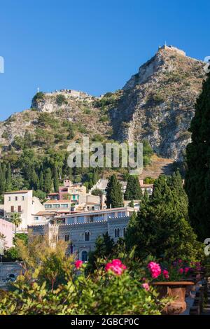 Taormina, Messina, Sizilien, Italien. Blick von den Gärten der Villa Comunale auf die Kapelle der Madonna della Rocca und die Ruinen der Burg Sarazenen. Stockfoto