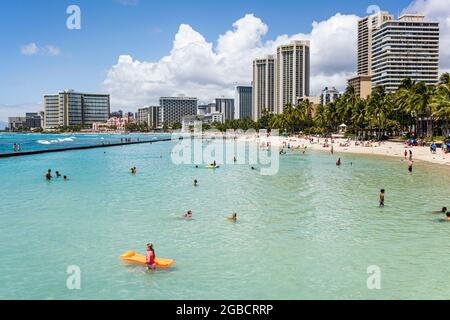 Honolulu Hawaii, Oahu, Hawaiian, Waikiki Beach Kuhio Beach Park Pazifischer Ozean, Sheraton Hyatt Regency Schwimmer Badegäste Sonnenanbeter, City Skyline Hochhaus h Stockfoto