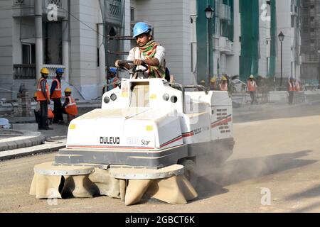 Neu Delhi, Indien - 9. August 2015:Bauarbeiter Auftragnehmer Mann fährt amphibisch getrackte Fahrzeug Seitenansicht auf der Bauseite Stockfoto