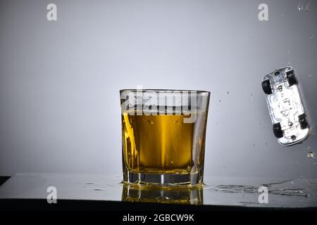 Das Auto ertrinkt im Alkoholglas-, Getränke- und Fahrkonzept Stockfoto