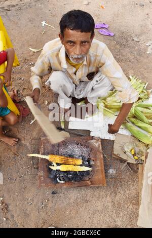 Indien, Delhi, 24. August 2018:Verkauf von geröstenem Maiskolben auf heißen Kohlen Stockfoto