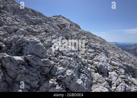 Felsiges Gelände und viele Wanderer auf dem Weg zum Gipfel des Watzmann Hocheck, Ramsau, Berchtesgaden, Bayern, Deutschland Stockfoto