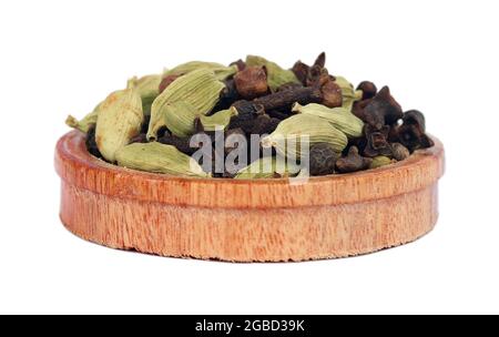 Kombination aus Kardamom, Nelken und Paprika in einer Holzschüssel auf weißem Hintergrund Stockfoto
