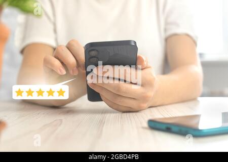 Kunden Bewertungen Konzept mit Bewertung oder Feedback-Symbol, Gold fünf-Sterne-Bewertservice, Frau mit Smartphone Stockfoto