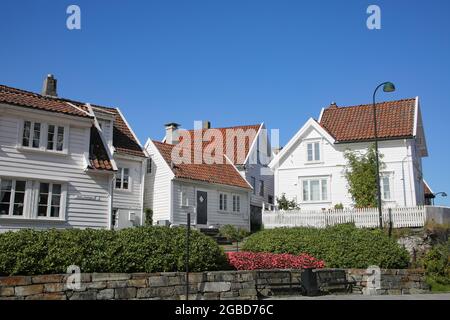 Traditionelle Holzhäuser, die weiß mit roten Dächern gestrichen sind. Das Hotel liegt in Gamle Stavanger, einem historischen Viertel der Stadt Stavanger, Norwegen.
