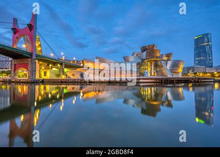 BILBAO, SPANIEN - 10. Juli 2021: Das futuristische Guggenheim Museum spiegelt sich im Morgengrauen im Fluss Nervion wider Stockfoto