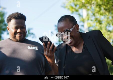 Oakwood, Usa. August 2021. Die sozialdemokratische Kandidatin Nina Turner telefoniert, während sie von dem Demokraten aus Louisiana, Gary Chambers, unterstützt wird. Die Wähler kamen zu den Wahlurnen für eine Sonderwahl im 11. Bezirk von Ohio. Die beiden führenden Kandidaten für den Sitz dieses Repräsentantenhauses sind zwei Demokraten, Nina Turner, eine progressive Kandidatin, und Shontel Brown, die das traditionelle demokratische Establishment vertritt. Kredit: SOPA Images Limited/Alamy Live Nachrichten Stockfoto