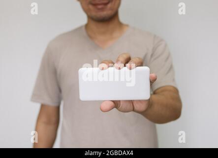 Nahaufnahme Mann mit weißer Powerbank. Mann mit braunem Hemd mit Energiereserven. Stockfoto