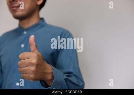 Junger, hübscher Mann mit hellblauem Hemd und verschiedenen Verhaltensweisen bei der Arbeit Stockfoto