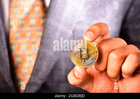 Business in Suit zeigt Bitcoin, Bitcoin in der Hand Stockfoto