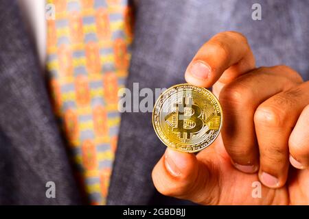 Kryptowährung Golden Bitcoin, Geschäftsmann hält Bitcoin in der Hand Stockfoto