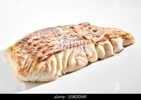 Nahaufnahme lecker frisch gebratenes Pollack Fischsteak mit knuspriger Kruste auf weißem Hintergrund platziert Stockfoto
