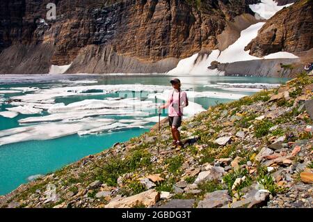 Wanderer halten inne, um Eis im Upper Grinnell Lake, Many Glacier, Glacier National Park, Montana zu sehen Stockfoto