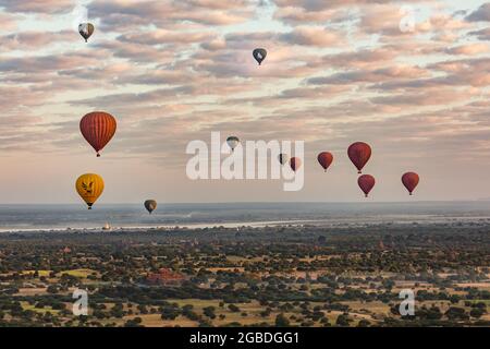 Bei Sonnenaufgang fliegen viele Ballons über das mystische Weltkulturerbe Bagan in Myanmar Stockfoto