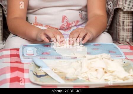 Hausfrau, die Käse in Yufka legt, macht traditionelle türkische sigara Boregi (Zigarette borek). Stockfoto