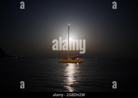 Boot unter dem Mond, reflektiert das Mondlicht Stockfoto