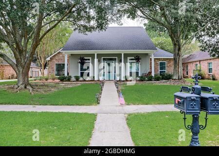 Eine Vorderansicht eines akadischen renovierten Hauses mit Säulen, Gehwegen und einer farbenfrohen Eingangstür, die kürzlich mit dem sich verändernden Immobilienmarkt gekauft wurde Stockfoto