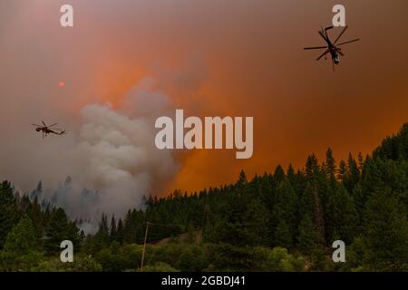 Heugabel, USA. August 2021. Am 1. August 2021 kreisen zwei Hubschrauber um einen Abschnitt des McFarland Wildfire in der Nähe der Heugabel, CA, und lassen Wasser fallen. (Foto: Daniel Brown/Sipa USA) Quelle: SIPA USA/Alamy Live News Stockfoto