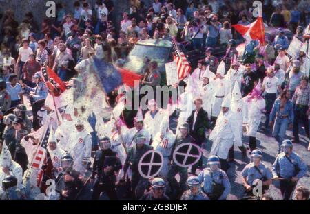 Austin, Texas, USA, um 1983: Eine kleine Gruppe von Ku Klux Klan-Mitgliedern, flankiert von der Polizei, zieht durch die Innenstadt von Austin, wo sie von einer feindlichen Anti-KKK-Menge getroffen werden. ©Bob Daemmrich Stockfoto