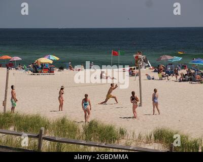 Beachvolleyballspieler genießen ein Spiel am Strand in Ocean County, New Jersey. Stockfoto