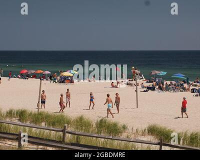 Beachvolleyballspieler genießen ein Spiel am Strand in Ocean County, New Jersey. Stockfoto