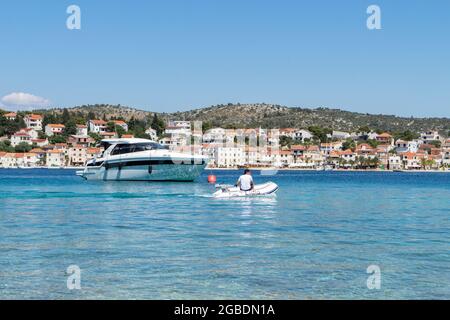 Rogoznica, Kroatien-06.Juli 2021: Mann mit Schlauchboot in der wunderschönen blauen Bucht von Rogoznica, Kroatien Stockfoto