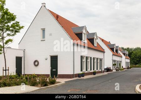 Thorn, Niederlande, 24. Juni 2021. Weiße, moderne Häuser mit orangefarbenem Dach in einem Dorf in Limburg, das für seine weißen Häuser und Gebäude bekannt ist. Str Stockfoto