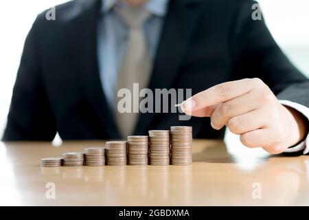 Nahaufnahme eines Geschäftsmannes, der Stapel Münzen macht Stockfoto