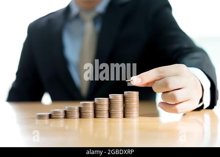 Geschäftsmann Hand Putting Geld Münzstapel wachsendes Geschäft. Stockfoto