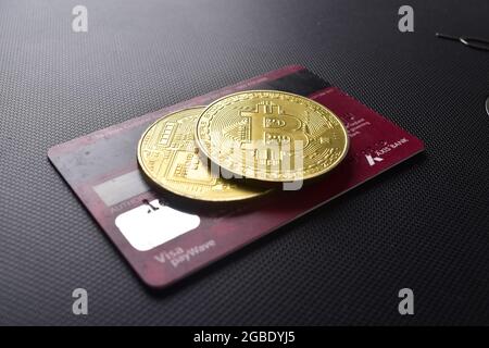 Bitcoin mit Kreditkarte auf dunklem Hintergrund, Bitcoin kaufen Stockfoto